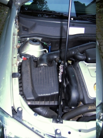 Opel Astra&reg; G (1998-2004): Blick auf Ansaugschlauch, Luftfilterkasten & Lichtmaschine unter dem Ansaugschlauch.