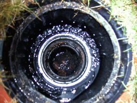 Ansicht des Rewalux® WISY Wirbel-Fein-Filters bei Regendurchfluss. Bis mittelstarkem Regen wird zufließendes Wasser - wie hier zu sehen - komplett durch das Filtersieb in die Zisterne geleitet. Erst Starkregen spült den Filter sauber.