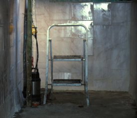 Gemauerte Regenwasser-Zisterne - Innenansicht mit Leiter und Tauchdruckpumpe.